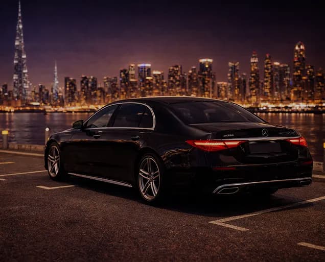 A line of professional chauffeurs standing in front of luxury black cars with Dubai skyline background